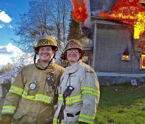 Ramsey Mueller and his mother, Deputy Chief Faith Mueller, stand in front of a controlled training burn on March 26, 2016.