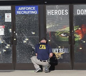 An FBI investigator investigates the scene of a shooting outside a military recruiting center on Friday, July 17, 2015, in Chattanooga, Tenn. (AP Image)
