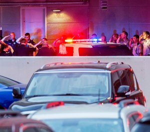 In this Tuesday, June 25, 2019 photo, law enforcement officers from numerous jurisdictions in central Illinois salute at the emergency entrance at OSF Saint Francis Medical Center in Peoria, Ill. (David Zalaznik/Journal Star via AP)