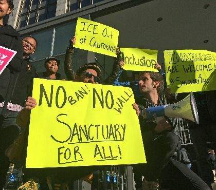 In this April 14, 2017, file photo, protesters hold up signs outside a courthouse where a federal judge was to hear arguments in the first lawsuit challenging President Donald Trump's executive order to withhold funding from communities that limit cooperation with immigration authorities in San Francisco.