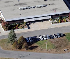 This Oct. 28, 2013 aerial photo shows the Sandy Hook Elementary School, relocated to the former Chaulk Hill School building in Monroe, Conn., after the original building in neighboring Newtown was razed following A Dec. 14, 2012, shooting rampage where 26 people were killed. A threat Wednesday, Oct. 1, 2014, led to the evacuation of the new Sandy Hook Elementary School in Monroe. The superintendent's office said the students were being moved to a nearby school where they could be picked up by their parents. (AP Photo/Jessica Hill)