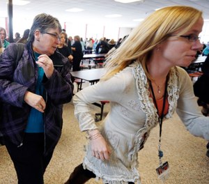 Participants rush out of the cafeteria after hearing gun shots during a lockdown exercise at Milford High School in Milford, Mass. (AP Photo/Michael Dwyer, File)