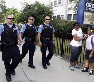In this Aug. 26. 2013, file photo, Chicago Police patrol the neighborhood at Gresham Elementary School on the first day of classes in Chicago. (AP Image)