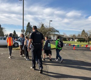 Eugene police officers and teachers escort students at Cascade Middle School in Eugene, Ore., Friday, Jan. 11, 2019.