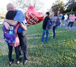 Family member embrace following a shooting at Marjory Stoneman Douglas High School, Wednesday, Feb. 14, 2018, in Parkland, Fla.
