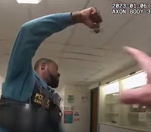 In one clip, an officer can be seen leading children down the hallway while cheerfully saying, 
