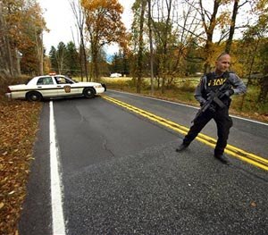 A Pennsylvania State Trooper patrols along a closed section of Lower Swiftwater Road on Saturday, Oct. 18, 2014, during a massive manhunt for killer Eric Frein in Swiftwater, Pa. (AP Image)