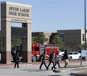 In this Jan. 13, 2014 file photo, students pass by Seven Lakes High School after being evacuated and released from school for the day after a bomb squad was called.