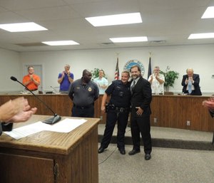 Ted Westmoreland poses with an officer after being presented a meritorious service award. (Photo the Independent Mail)