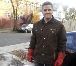 In this November 2012 file photo provided by Nicole Lynch, her brother, Sean Collier, stands in his driveway in Somerville, Mass.
