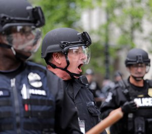 A Seattle police officer yells out orders at Seattle City Hall as protesters march toward them Wednesday, June 3, 2020, in Seattle. (Photo/AP)