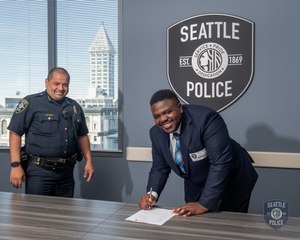 Chief Adrian Diaz signs on a new officer. Roughly 400 deployable officers have left the force since 2018.