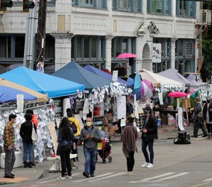People walk near tents that make up the