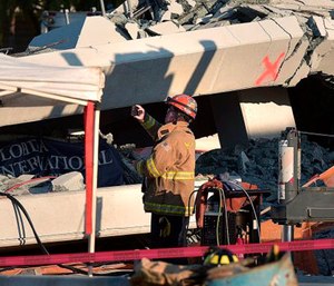 A Miami-Dade Fire Rescue firefighter takes pictures after a brand new, 950-ton pedestrian bridge collapsed in front of Florida International University. (Michael Laughlin/South Florida Sun-Sentinel via AP)