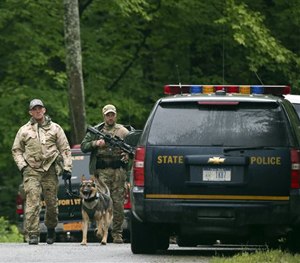 Law enforcement officers walk along a road on Sunday, June 28, 2015. (AP Image)