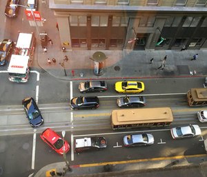 A fire truck at top left and other traffic try to make their way around a pair of idled cablecars on California Street after a large power outage.