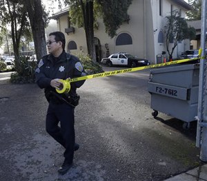 A San Francisco Police puts up yellow tape to block the entrance to Park Police Station in San Francisco, Saturday, Jan. 30, 2016.