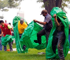 Volunteers learn to deploy fire shelters with practice equipment after a call out by fire officials seeking to supplement their usual resources in Omak, Wash.