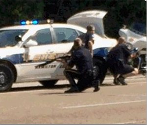 In this image made from video and released by WRCB-TV, authorities work an active shooting scene on amincola highway near the Naval Reserve Center, in Chattanooga, Tenn. on Thursday, July 16, 2015. (WRCB-TV via AP)
