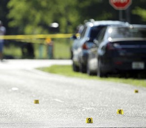 Evidence markers are placed on the street at the scene of a deadly shooting outside of the Club Blu nightclub, Monday, July 25, 2016, in Fort Myers, Fla. (AP Image)