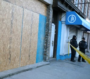 Police officers stand near the scene of a gun fight at a kosher supermarket in Jersey City, N.J. The state attorney general confirmed the shooting is being investigated as an act of domestic terrorism.