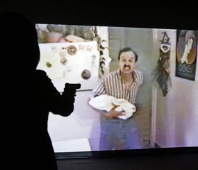 In this Feb. 27, 2014 photo, a television reporter uses a specially modified gun to try to shoot a hostage taker during a demonstration of the Harris County district attorney's shooting simulator, in Houston.