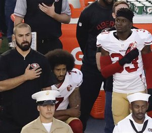 In this Thursday, Sept. 1, 2016 file photo, San Francisco 49ers quarterback Colin Kaepernick, middle, kneels during the national anthem before the team's NFL preseason football game against the San Diego Chargers, in San Diego. (AP Photo/Chris Carlson, File)