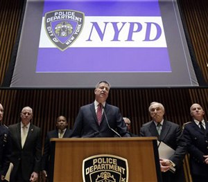 New York Mayor Bill de Blasio, center, accompanied by New York City Police Commissioner William Bratton, second from right, and other ranking NYPD officers, addresses a news conference at New York City Police headquarters, Monday, Jan. 5, 2015.
