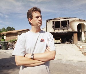 Scott Miller, the LAFD firefighter who got shot in the face during the 1992 riots, stands outside his fire-damaged home, May 17, 1996 in Newbury Park, Calif.
