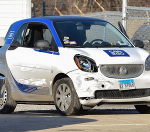 A suspect in a cell phone store robbery attempted to flee police in a SmartCar before hitting two police vehicles and pinning an officer inside a third. (Photo/TNS)