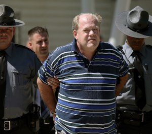 In this Tuesday, Sept. 3, 2019 photo, Pennsylvania state troopers lead Theodore Dill Donahue out of the Pennsylvania State Police Troop K barracks in West Philadelphia after arresting him as a suspect in the 1991 murder of Denise Sharon Kulb. (Tim Tai/The Philadelphia Inquirer via AP)