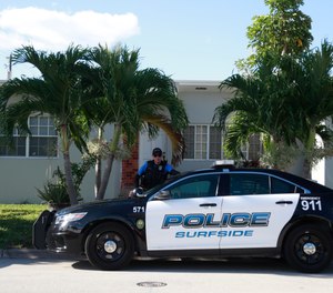 A town of Surfside, Fla., police officer stands guard in front of the home of Sol Pais, Wednesday, April 17, 2019, in Surfside, Fla.