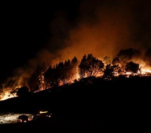 Firefighters watch from their fire trucks as wildfires continue to burn Thursday, Oct. 12, 2017, near Calistoga, Calif. (AP Photo/Jae C. Hong)