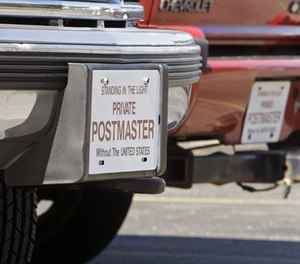 In this July 2, 2010 photo, two vehicles with no registered license plates are parked outside an apartment complex in Columbus, Ohio. James T. McBride, a member of the Sovereign Citizens movement, owns the vehicles and claims he doesn't have to register them because the U.S. government has no authority over citizens. (AP Photo/Jay LaPrete)