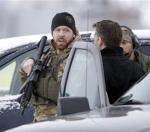 Members of the FBI stand guard at the Burns Municipal Airport, Sunday, Jan. 10, 2016, in Burns, Ore.