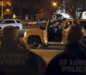 Police investigate a scene after a St. Louis police officer was shot in what the police chief called an