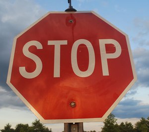 Police say a 19-year-old driver hit an ambulance after running a stop sign.