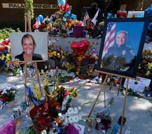 Mourners pay their respects on Oct. 10 at a memorial for two slain Palm Springs, Calif.