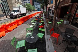 Orange barriers enclose chairs and tables that will be used for dining along Sixth Street between Liberty and Penn avenues in downtown Pittsburgh. Many local governments are offering creative solutions to get businesses back up and running as soon as possible. Image: AP Photo/Gene J. Puskar