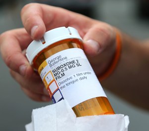 In this July 23, 2018, photo, newly-released inmate George Ballentine holds his prescription medicine Suboxone outside a pharmacy in Greenfield, Mass.