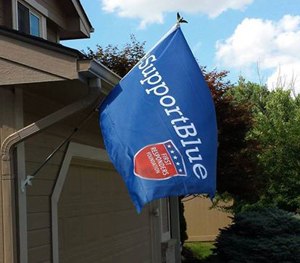 A Support Blue flag hangs in front of a home.