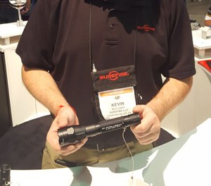 Surefire employee Kevin McCluskey holds up the newest version of the R1 Lawman rechargeable flashlight, which now includes IntelliBeam.