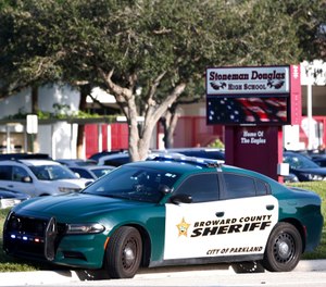 In an Aug. 15, 2018 file photo, a Broward County Sheriff's Office vehicle is parked outside Marjory Stoneman Douglas High School, in Parkland, Fla. (AP Photo/Wilfredo Lee, File)