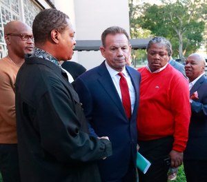 Suspended Broward County Sheriff Scott Israel, center, leaves a news conference surrounded by supporters in Fort Lauderdale, Fla.
