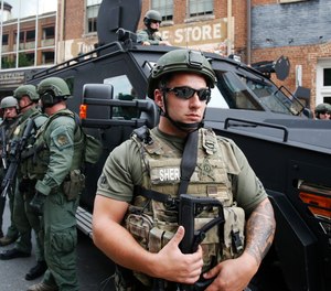 Members of a SWAT team keep an eye on demonstrators in Charlottesville, Va., Sunday, Aug. 12, 2018.