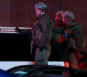 Denver Police Department SWAT team members survey Denver Broncos fans as they celebrate the team's victory over the Carolina Panthers in Super Bowl 50 near intersection of 15th and Champa Street late Sunday, Feb. 7, 2016, in Denver. (AP Photo/David Zalubowski)