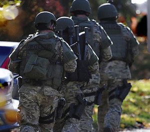 SWAT move in a line on the campus of Central Connecticut State University, Monday, Nov. 4, 2013, in New Britain, Conn.
