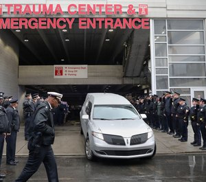 Police officers salute as the hearse carrying the body of Philadelphia police officer Cpl. James O'Çonnor leaves the hospital in Philadelphia, Pa. (Photo/TNS)
