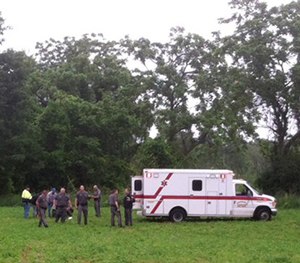 Police gather around David Sweat after he was shot and captured near the Canadian border Sunday, June 28, 2015. (AP Image)