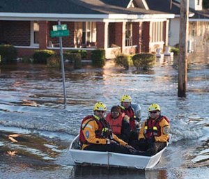 A swift water rescue team transports a resident of to safety on a street covered with floodwaters caused by rain from Hurricane Matthew in Lumberton, N.C. (AP Photo/Mike Spencer)
